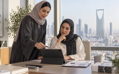 Two professionals working together in a Riyadh office overlooking the Kingdom Centre